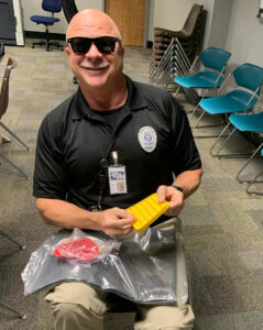 Police officer showing a yellow bubble popper fidget sensory toy from the Variety KC sensory kit