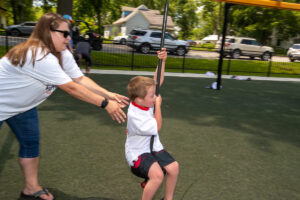 Mom pushing child on zip line at Variety KC splash pad in Lathrop